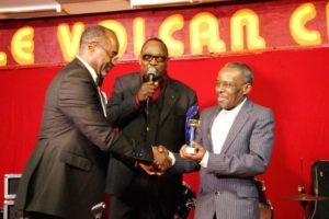 Pépé Félly qui remet à Luamba Mfumu Makanda Yves alias DEMUKUSE son trophée en 2013 lors de sa nomination dans la catégorie guitariste soliste de la nouvelle génération de la rumba congolaise moderne.